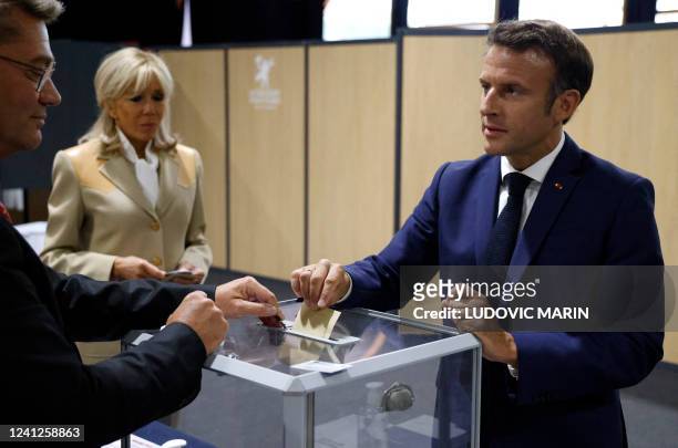 France's President Emmanuel Macron casts his vote followed by his wife, French first lady Brigitte Macron in French parliamentary elections at a...