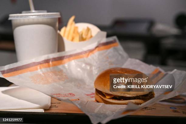 This photograph taken on on June 12, 2022 shows a double cheeseburger menu' including fries, sauce and a soft drink in the Russian version of a...