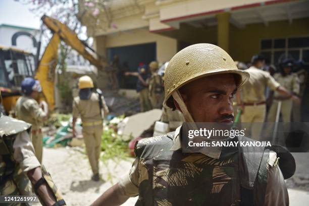 Members of Indian security personnel keep vigil during the demolition of the illegal structures of the residence of Javed Ahmed, a local leader who...