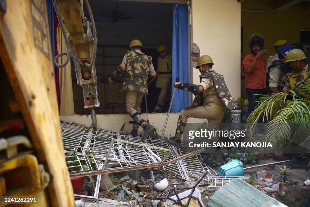 Members of Indian security personnel keep vigil during the demolition of the illegal structures of the residence of Javed Ahmed, a local leader who...