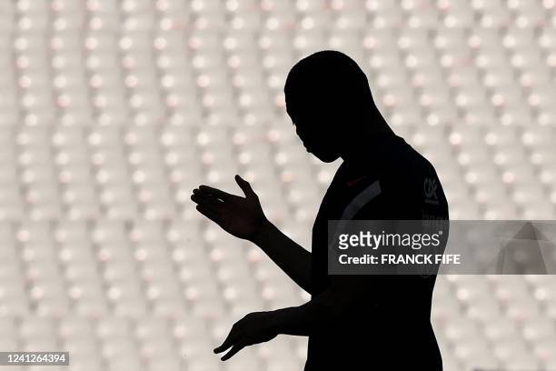 France's forward Kylian Mbappe is silhouetted during a training session at the Stade de France stadium in Saint-Denis, north of Paris on June 12,...