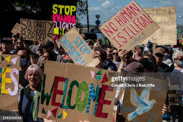 Protesters chant and hold placards against the UK deportation flights to Rwanda near Brook House Immigration Removal Centre on June 12, 2022 in...