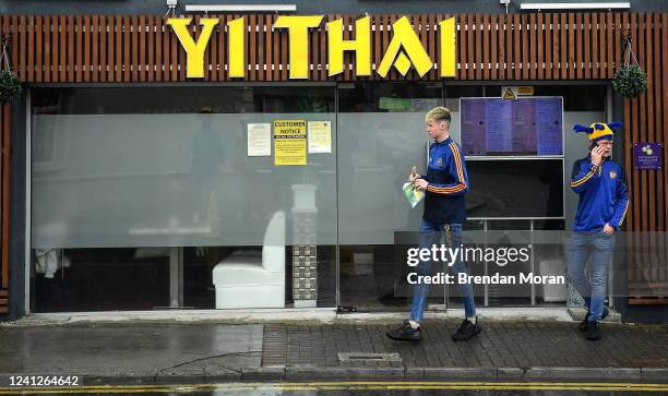 Tipperary , Ireland - 5 June 2022; Supporters shelter from the rain in the town centre before the Munster GAA Hurling Senior Championship Final match...