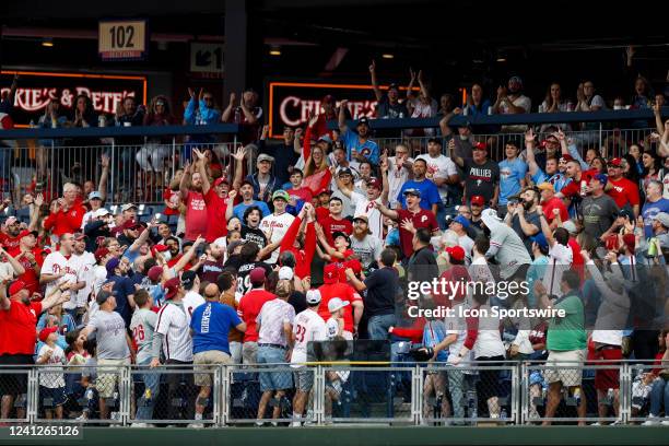 Fans reach up for a home run ball hit by Philadelphia Phillies third baseman Bryson Stott during a regular season game between the Arizona...