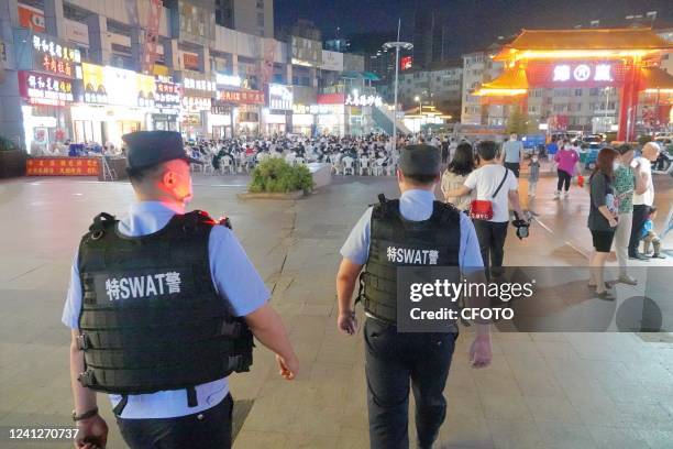 Police officers are on duty at a night market in Laishan District of Yantai, East China's Shandong Province, June 12, 2022. In the early morning of...