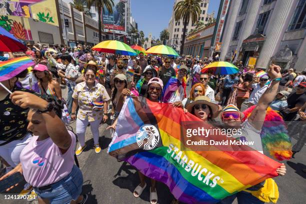 Marchers with Starbucks pass through the landmark intersection of Hollywood and Highland during the annual Pride Parade on June 12, 2022 in the...