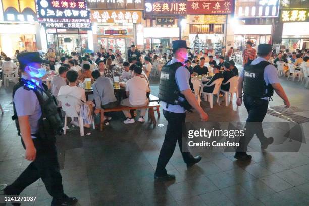 Police officers are on duty at a night market in Laishan District of Yantai, East China's Shandong Province, June 12, 2022. In the early morning of...