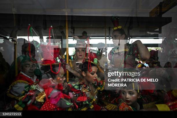 Revellers from the typical Lisbon neighbourhood, Alfama, are pictured inside a bus before attending the Santo Antonio de Lisboa's Parade on Avenida...