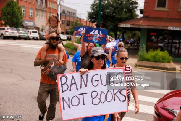 Woman holds a placard that says Ban Guns, Not Books, as gun control advocates participate in a 'March For Our Lives' rally and march in downtown...