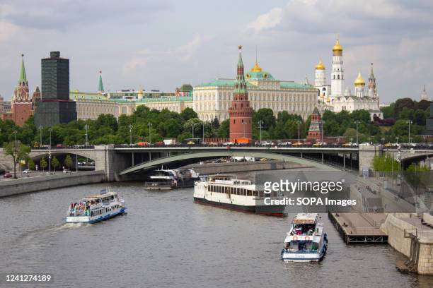 Boats navigate the Moscow River near the Kremlin.