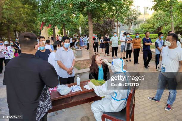 Residents line up for nucleic acid testing at huatong Century City residential community in Hua County, Anyang City, Central China's Henan Province,...