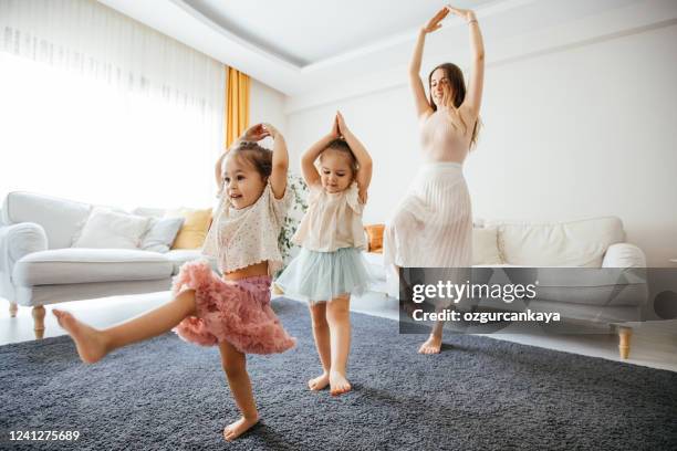 mother dancing with preschool daughters at home - girl singing imagens e fotografias de stock