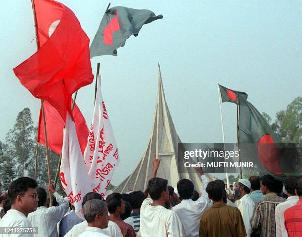 Hundreds of people gather holding national flags 26 March 1999 at the National Monument in the suburban Savar district of Dhaka to pay homage on its...