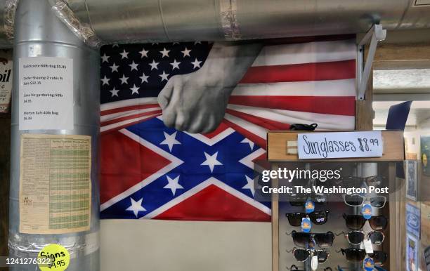 Poster featuring a hand pulling up an American flag to reveal a Confederate flag hangs on a wall at a roadside shop in White, Georgia on January 23,...