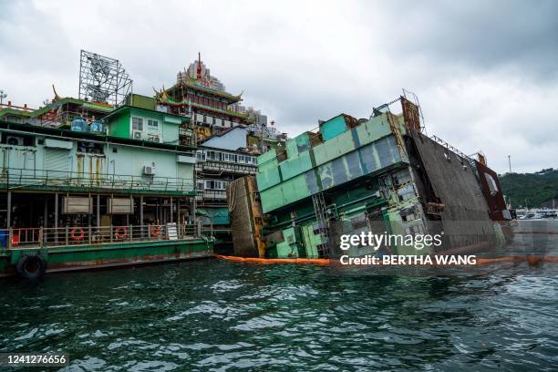 This photo taken on June 13, 2022 shows a kitchen barge attached to the main section of the Jumbo Floating Restaurant sitting on its side after...