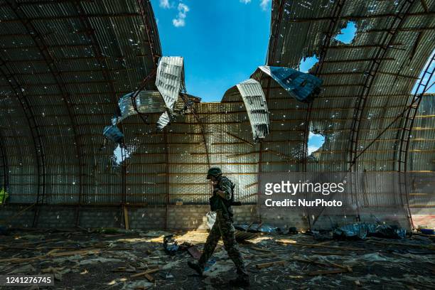 Ukrainian soldier walks inside a destroyed barn by russian shelling near the frontline of the Zaporizhzhia province, Ukraine. Harvest can not be...