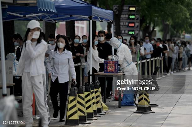People queue at a swab collection site to test for the Covid-19 coronavirus in Beijing on June 13, 2022.