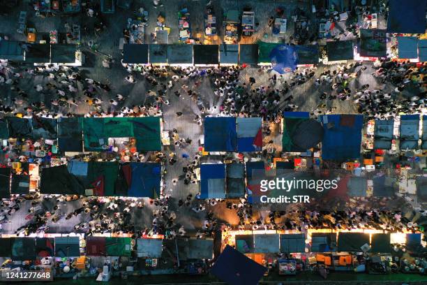 This aerial photo taken on June 11, 2022 shows people visiting a night market in Nanjing in China's eastern Jiangsu province. - China OUT / China OUT