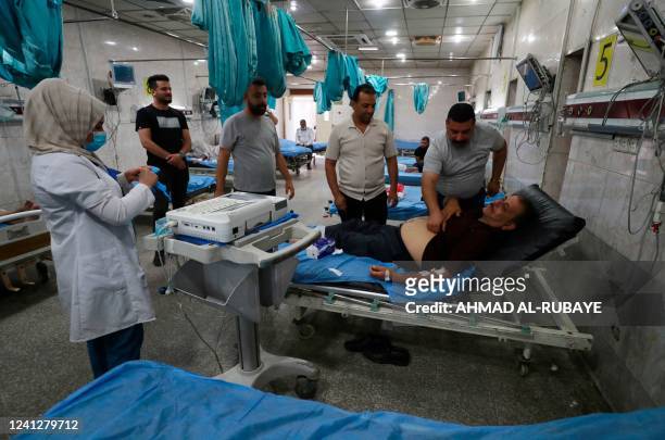 Iraqis receive treatment at an emergency ward at a hospital in Baghdad as choking clouds of dust blanketed the Iraqi capital on June 13, 2022 for the...