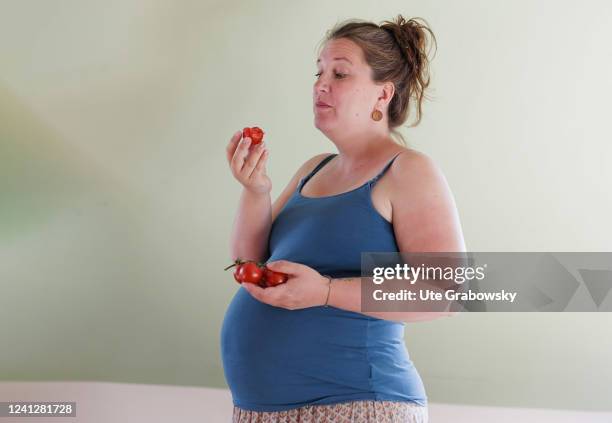 In this photo illustration Pregnant woman eats tomatoes on May 09, 2022 in Bonn, Germany.