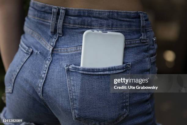 In this photo illustration a smartphone is stuck in a jeans pocket on May 09, 2022 in Bonn, Germany.