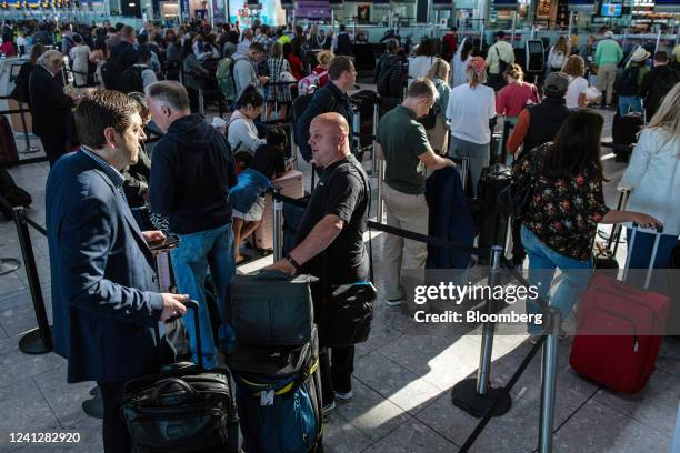 Passengers queue to check in at the departures hall of Terminal 5 at London Heathrow Airport in London, UK, on Monday, June 13, 2022....