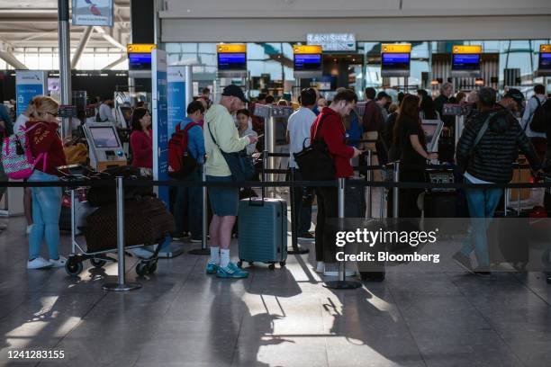 Passengers queue to check in at an American Airlines desks inside the departures hall of Terminal 5 at London Heathrow Airport in London, UK, on...