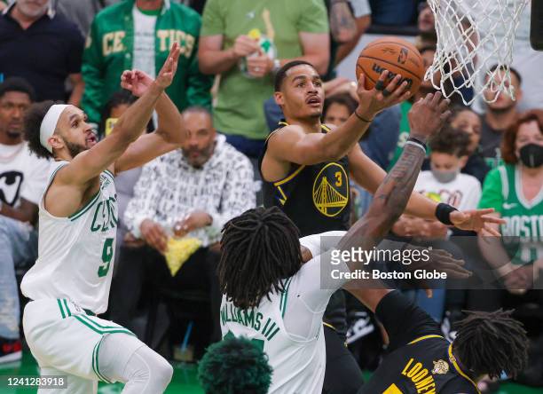 Golden State Warriors guard Jordan Poole drives to the basket with pressure from Boston Celtics guard Derrick White and center Robert Williams III...