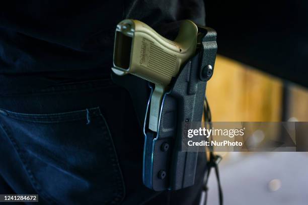 Man carries Glock handgun in a holster at LOK HTS Shooting CLub range in Krakow. In Krakow, Poland on June 11, 2022