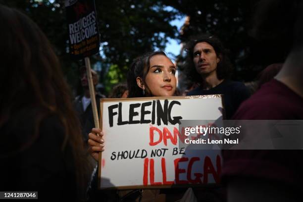 Woman holds a placard saying 'Fleeing danger should not be illegal' as people protest against the UK deportation flights to Rwanda outside the Home...
