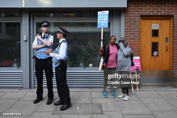 Woman holds a placard saying 'Scrap the nationalities and borders bill' as they are seen behind police officers during a protest against the UK...