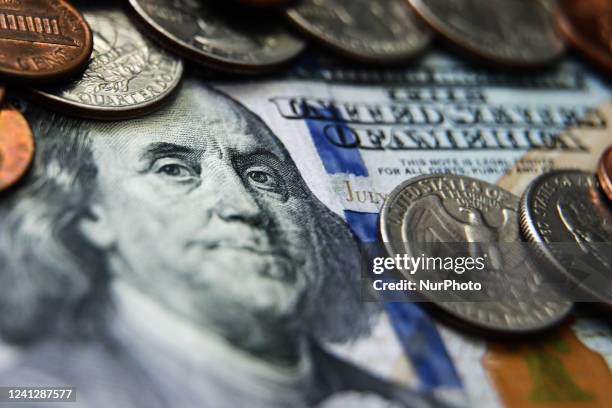 United States one hundred dollar banknote is seen with coins in this illustration photo taken in Krakow, Poland on June 13, 2022.