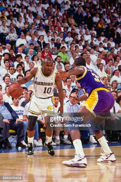 Tim Hardway Sr. Handles the ball during a game defended by Magic Johnson of the Los Angeles Lakers in 1991 at The Oakland-Alameda County Coliseum...