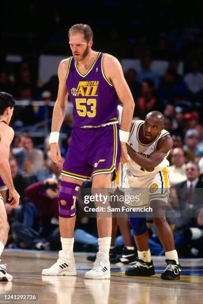 Mark Eaton Utah Jazz looks on as Tim Hardaway of the Los Angeles Lakers peeks around him during a game in 1993 at The Oakland-Alameda County Coliseum...