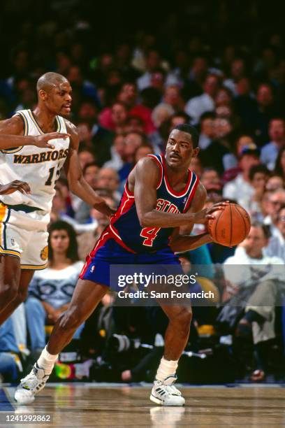 Joe Dumars of the Detroit Pistons passes the ball against Latrell Sprewell of the Golden State Warriors during a game in 1993 at The Oakland-Alameda...