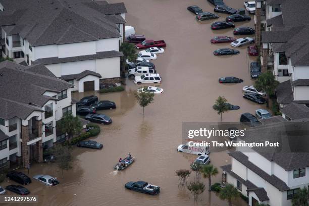 People in a boat search for people to rescue as flood waters surround houses and apartment complexes in West Houston, TX on Wednesday, Aug 30, 2017....