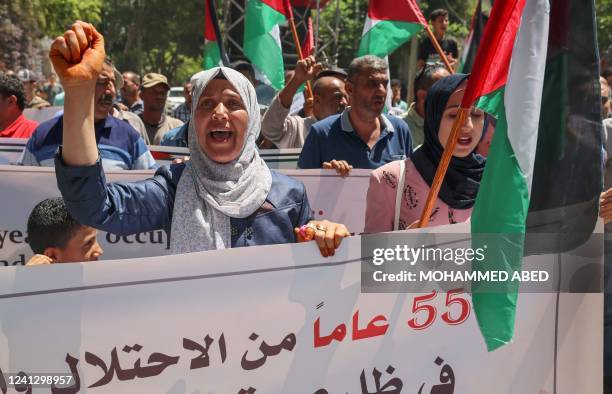 Palestinians take part in a protest commemorating the capture of the Gaza Strip by Israel 55 years ago and its 15th year of blockade, in front of the...