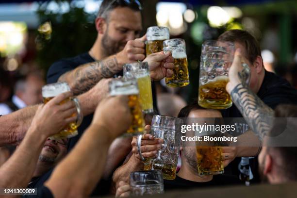 Customers make a toast at a beer garden in the Victuals Market in Munich, Germany, on Saturday, June 11, 2022. Confidence in the German economy...