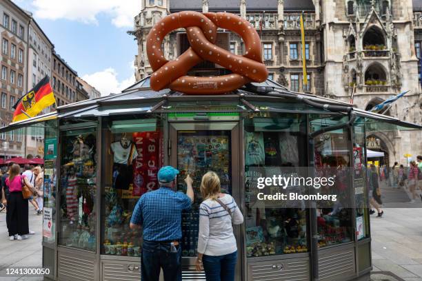 Customers look at Germany and Munich themed stickers, badges and other mementos at a souvenir kiosk in Munich, Germany, on Saturday, June 11, 2022....