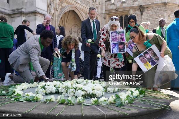 People place white roses in memory of the victims at a Grenfell fire memorial service at Westminster Abbey on June 14, 2022 in London, England. On 14...
