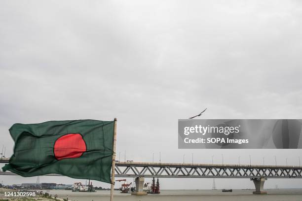 The national flag of Bangladesh is seen in front of the Padma Bridge across the Padma River in Dhaka. Bangladesh is set to open the long-awaited...