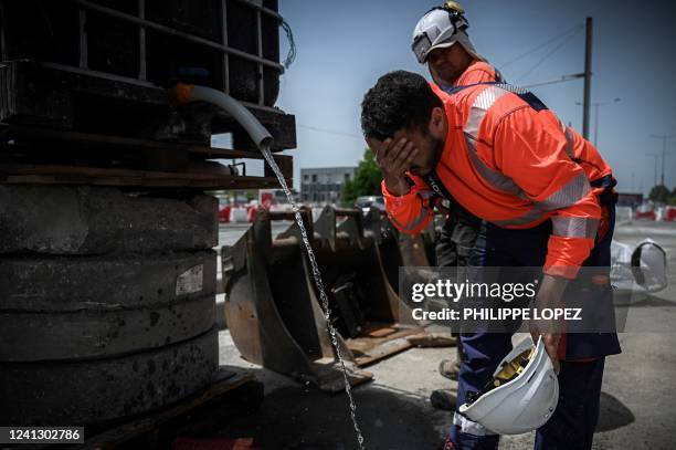 Man cools off with water as he works at a construction site during a hot day in Merignac, outside Bordeaux, southwestern France, on June 14, 2022 as...