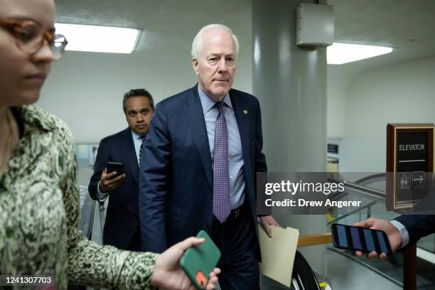 Sen. John Cornyn talks with reporters as he walks through the Senate subway on his way to a lunch meeting with Senate Republicans at the U.S. Capitol...
