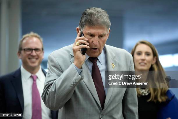 Sen. Joe Manchin talks on the phone as he walks through the Senate subway on his way to a lunch meeting with Senate Democrats at the U.S. Capitol on...