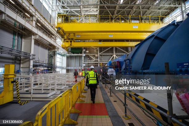 Worker walks near the turbine deck and generator at the third-generation European Pressurised Reactor project nuclear reactor of Flamanville,...