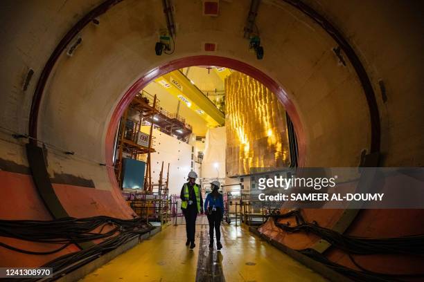 Workers walk in the reactor building equipment entry at the third-generation European Pressurised Reactor project nuclear reactor of Flamanville,...
