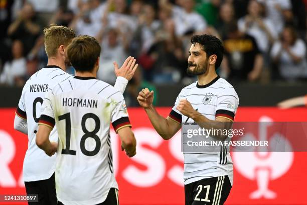 Germany's midfielder Ilkay Gundogan celebrates scoring the 2-0 goal from the penalty spot with his teammates Germany's midfielder Jonas Hofmann and...