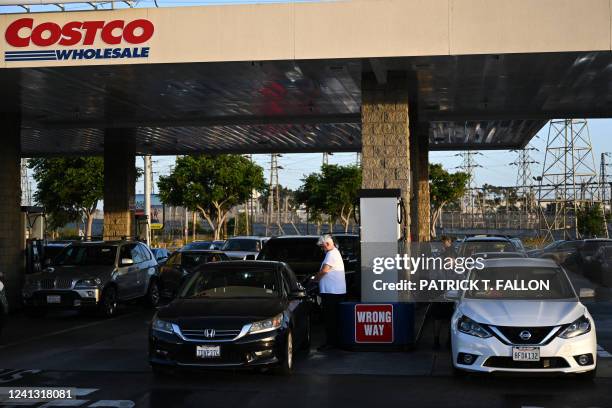 Drivers pump gasoline into vehicles as the price of regular gas reaches above $5.89 a gallon and premium fuel is priced over six dollars per gallon...