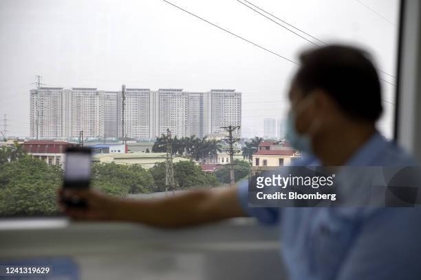Man records the scenery with his mobile phone through the window of the train in Hanoi, Vietnam, on Saturday, June 11, 2022. Asian stocks posted...