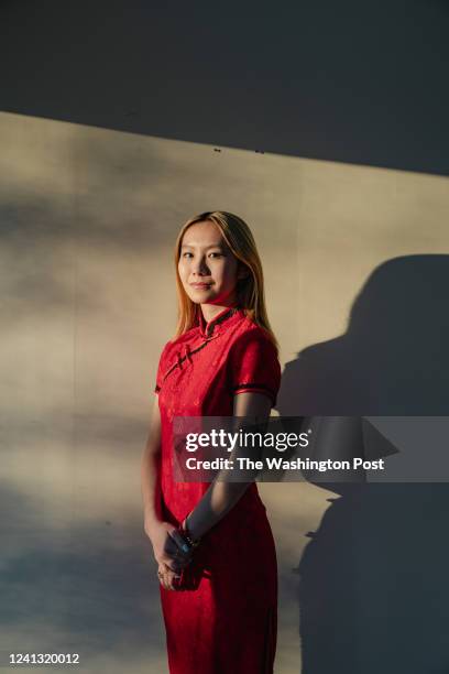 Jada Bromberg stands for a portrait in cheongsam, , a close-fitting dress that originated in 1920s Shanghai, in the sun room of her house in Fairfax,...